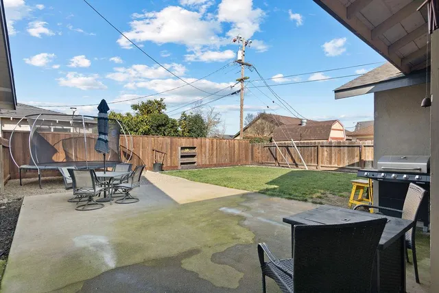 a view of a patio with a table chairs and barbeque grill