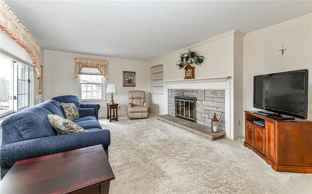 a living room with furniture a flat screen tv and a fireplace