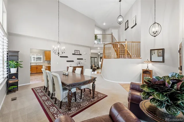 a living room with furniture kitchen view and a chandelier