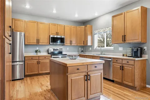 a kitchen with a stove a sink dishwasher a refrigerator and a microwave