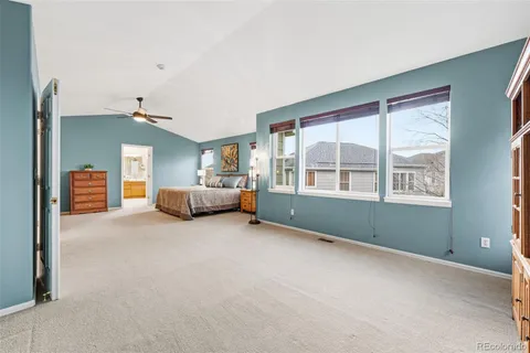 a view of an empty room with window and hardwood