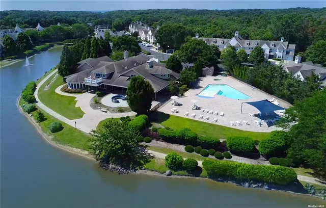 an aerial view of a house with a garden and lake view