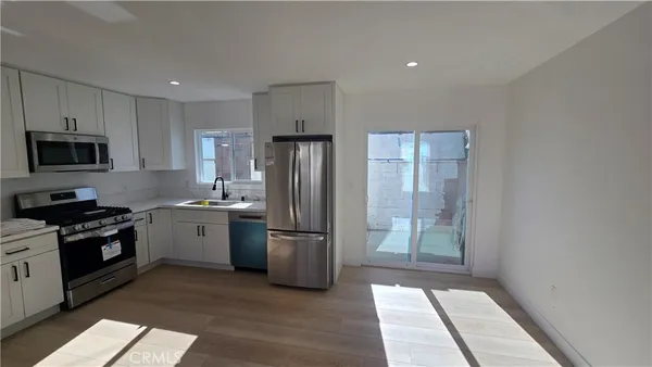 a kitchen with a refrigerator and a stove top oven
