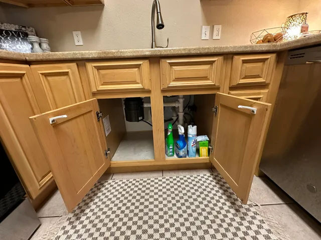 an empty room with chandelier fan and windows