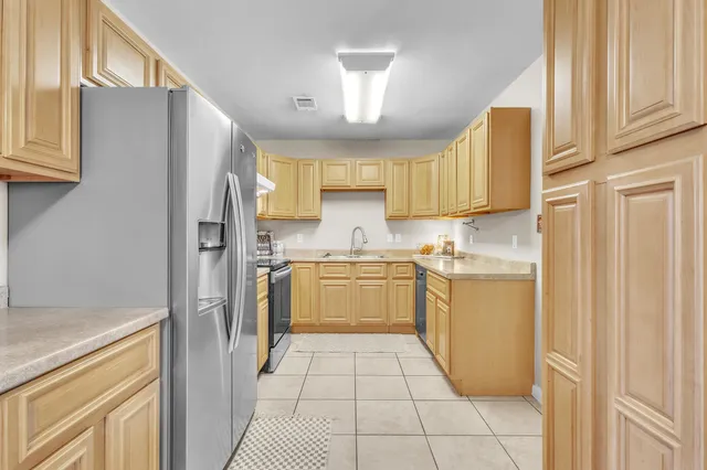 an empty room with chandelier fan and windows