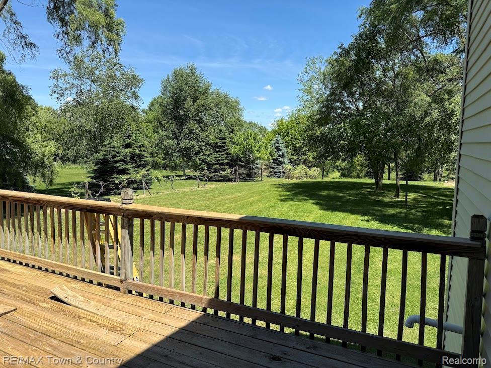 4372 North Gale Road Davison, MI 48423 - Photo 44 of 46 Expansive backyard featuring a manicured lawn, mature trees, and a wooden deck