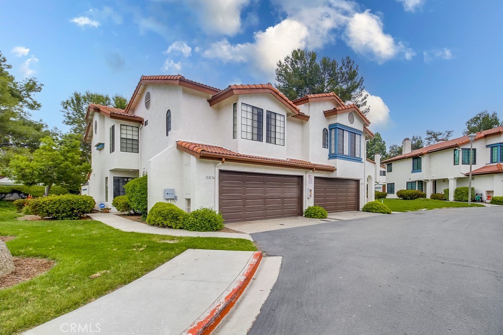a front view of a house with a yard and trees