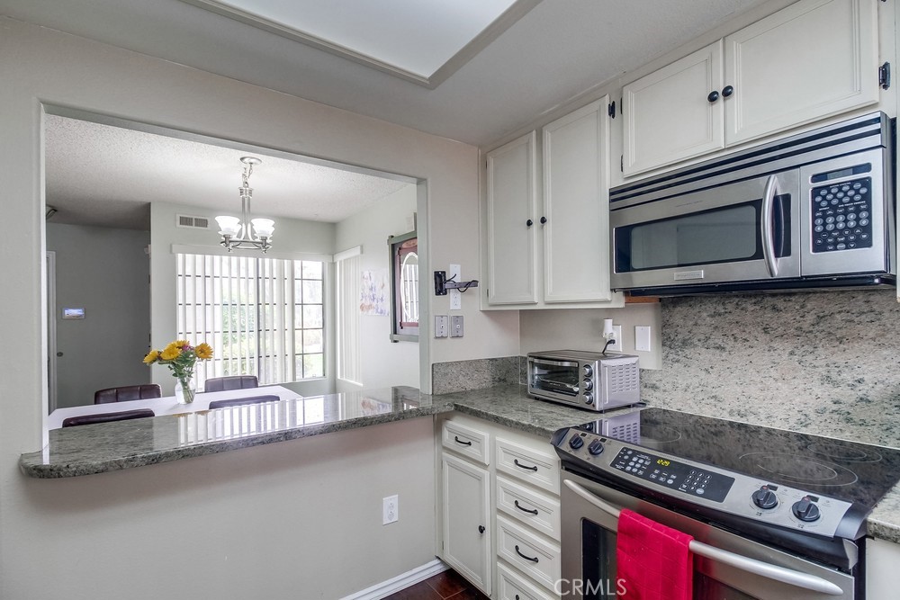1567 Apache Drive, Unit A Chula Vista, CA 91910 - Photo 15 of 51 a kitchen with stainless steel appliances granite countertop a stove a sink and a microwave