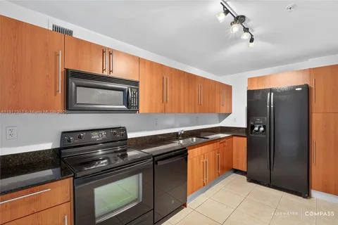 a kitchen with stainless steel appliances granite countertop a stove a refrigerator and a microwave