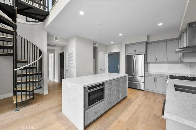 a kitchen with stainless steel appliances granite countertop a stove a sink and a refrigerator