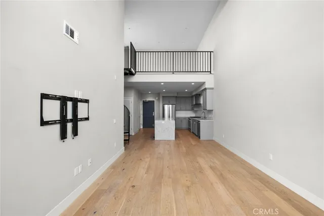 a view of a kitchen with fridge and wooden floor