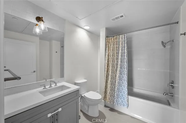 a bathroom with a shower sink vanity mirror and toilet