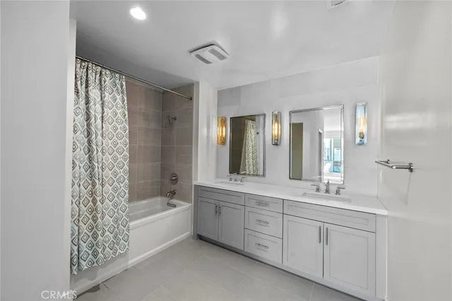 a spacious bathroom with a double vanity sink a large mirror and shower