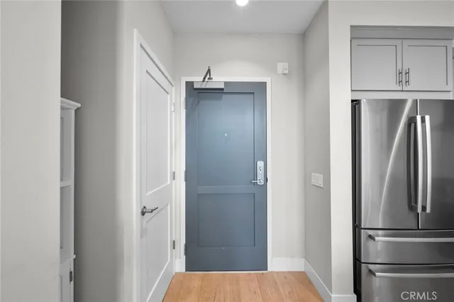 a view of kitchen with refrigerator cabinets and wooden floor