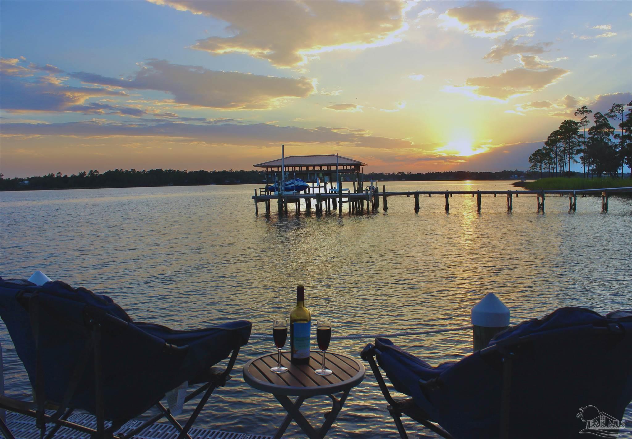 7809 Petersen Point Road Milton, FL 32583 - Photo 1 of 33 a view of a lake with a table and chairs