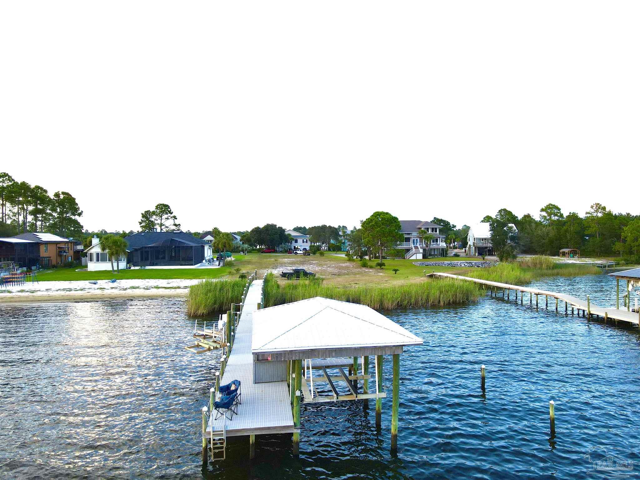 7809 Petersen Point Road Milton, FL 32583 - Photo 16 of 33 a view of lake with table and chairs under an umbrella