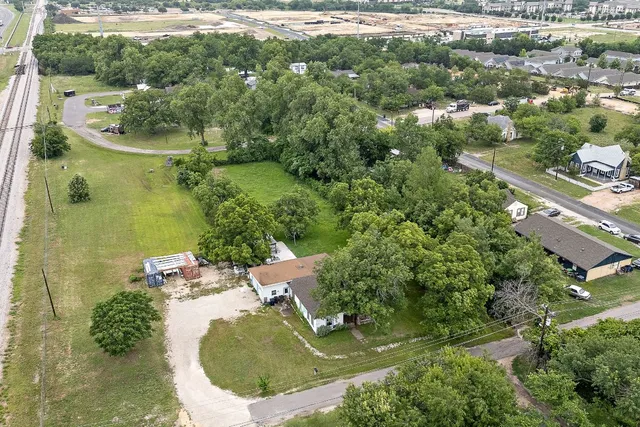 an aerial view of a house with yard swimming pool and green space