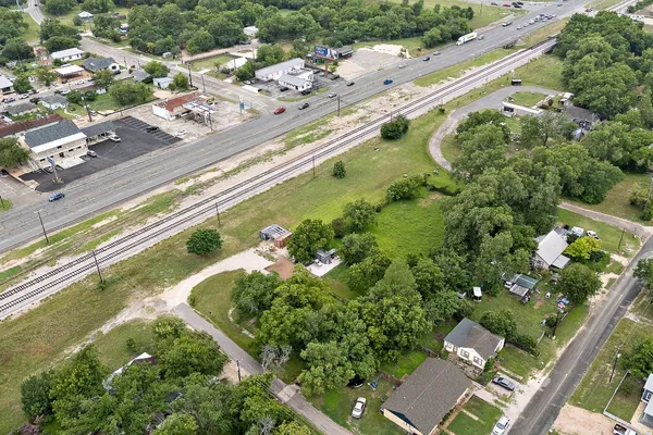 an aerial view of a residential houses with a yard and lake view