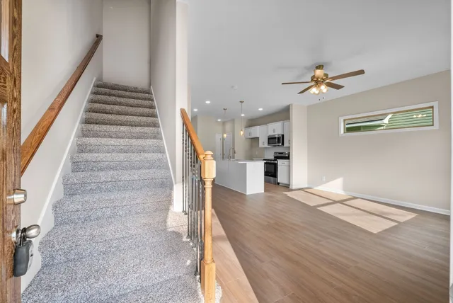 a view of a hallway with wooden floor and staircase