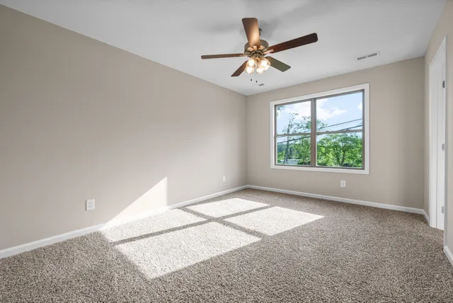 a view of a livingroom with a ceiling fan and window