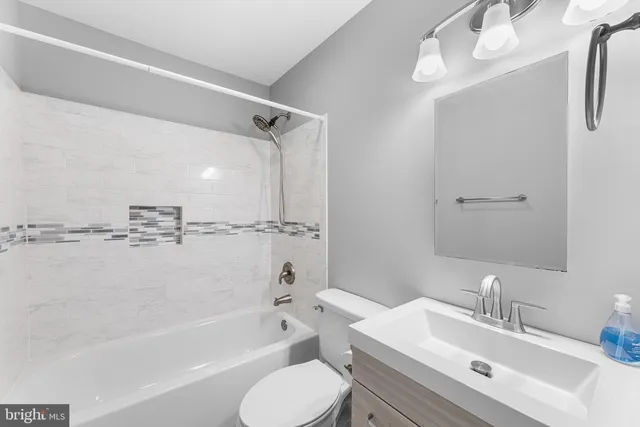 a bathroom with a bathtub shower sink vanity and toilet