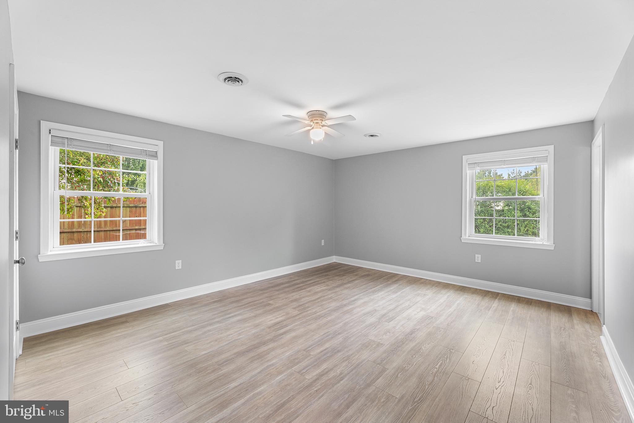 7384 Brett Road Easton, MD 21601 - Photo 13 of 29 an empty room with wooden floor and windows