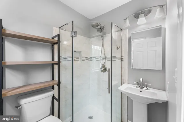 a bathroom with a sink mirror and shower
