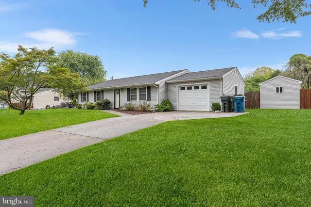 a front view of a house with a garden and yard
