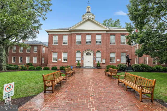 a view of a brick house with a yard in front of it