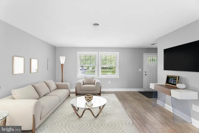 a living room with furniture a flat screen tv and a large window