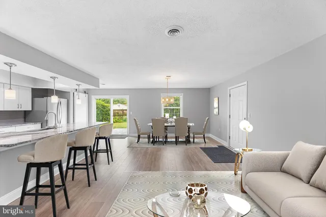 a living room with furniture wooden floor and a large window