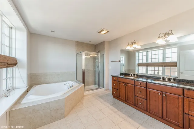 a spacious bathroom with a tub sink shower and mirror