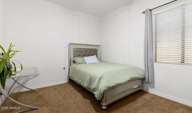 a bed sitting in a bedroom next to a window