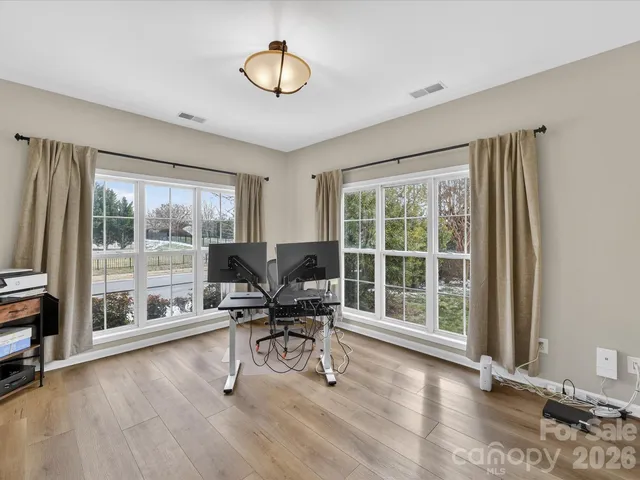 a view of a workspace with furniture and a window