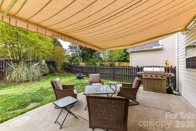 a patio with glass top table and chairs