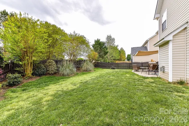 a backyard of a house with table and chairs