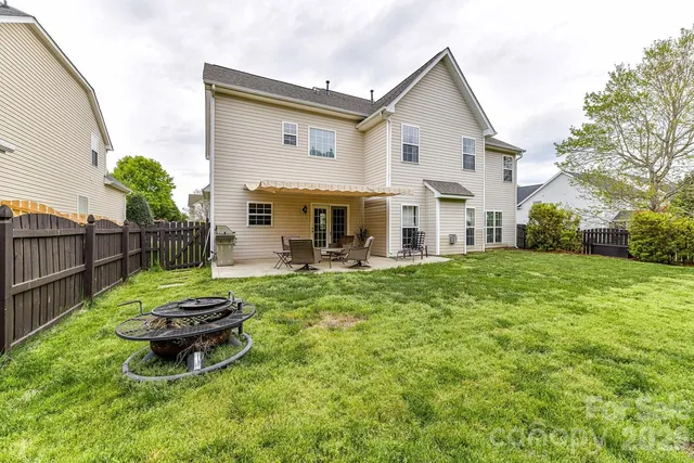 a view of a house with backyard and sitting area