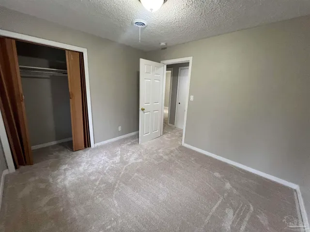 an empty room with closet and mirror