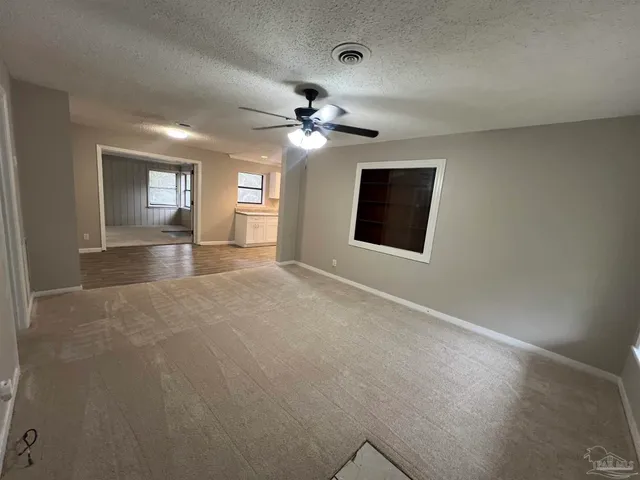 a view of a room with a ceiling fan and a window