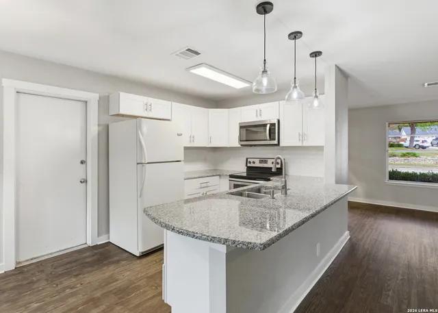 a kitchen with stainless steel appliances granite countertop a sink refrigerator and microwave