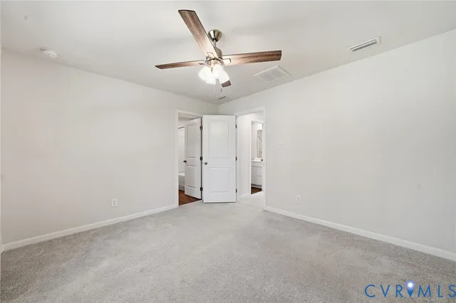 an empty room with a ceiling fan and a window