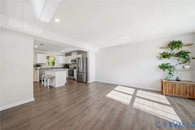 a view of a kitchen with wooden floor and electronic appliances