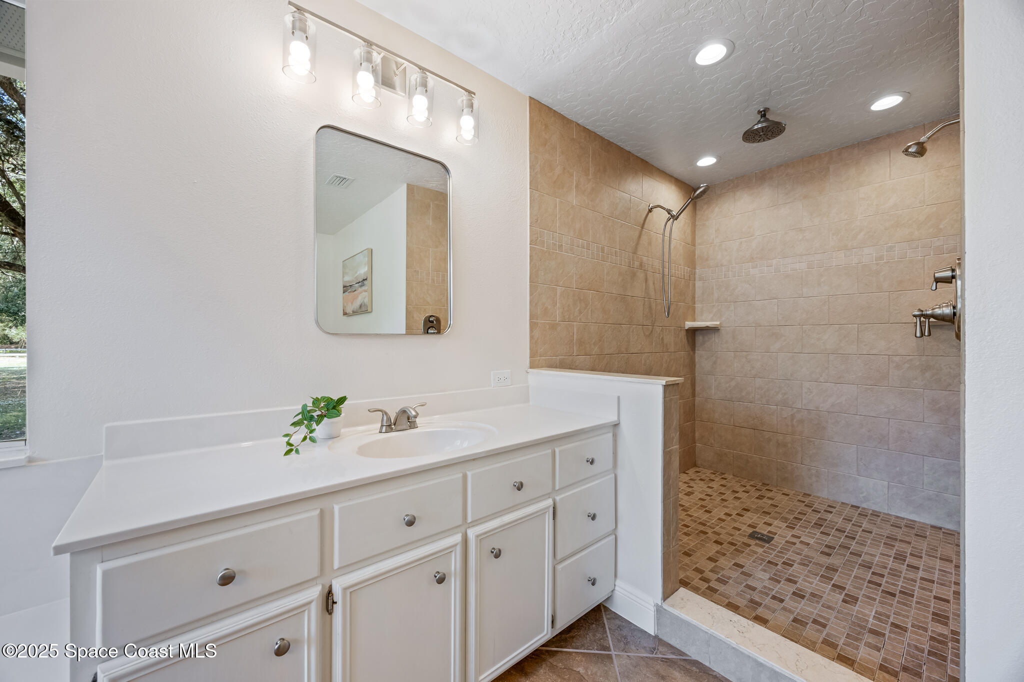 2190 Winston Drive Cocoa, FL 32926 - Photo 25 of 59 a bathroom with a shower sink and mirror