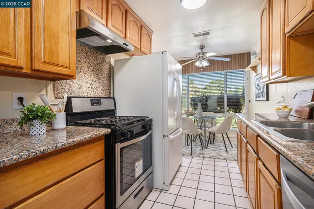 a kitchen with stainless steel appliances granite countertop a stove a sink and a microwave