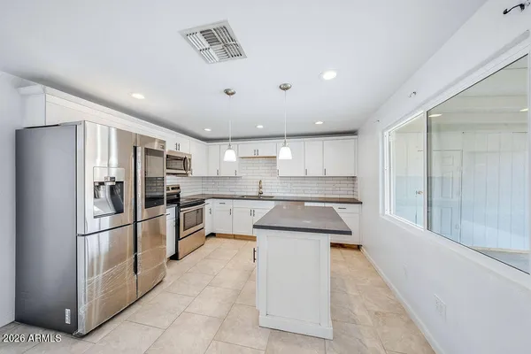 a large kitchen with cabinets and stainless steel appliances