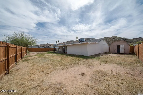 a view of a dry yard with wooden fence