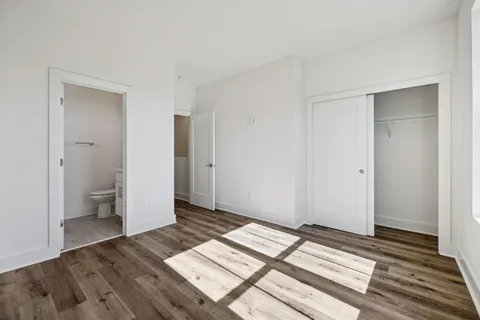 a view of a room with wooden floor and a bathroom