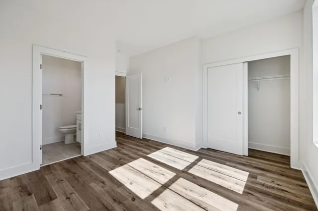 a view of a room with wooden floor and a bathroom