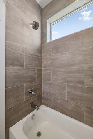 a bathroom with a white bath tub sitting next to a white sink and a shower
