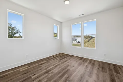 an empty room with wooden floor and window